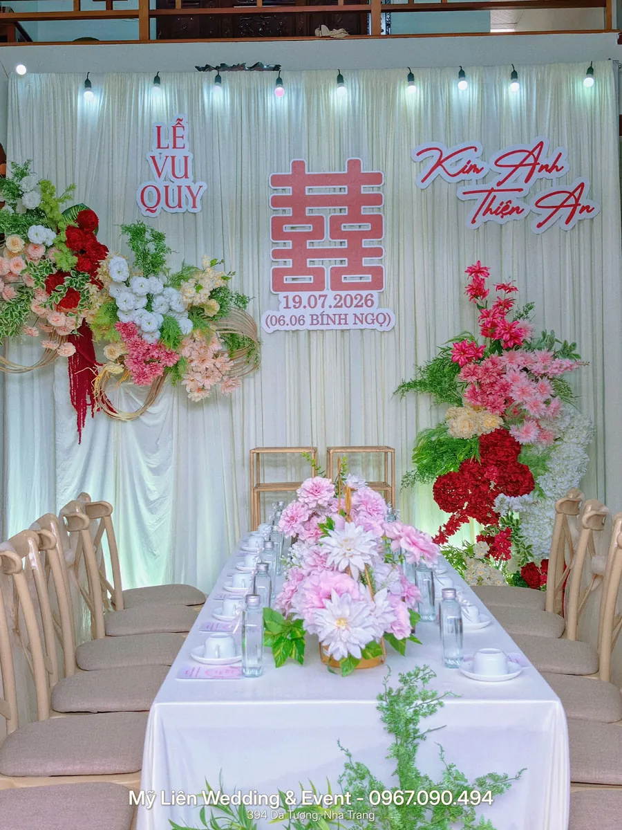 Bàn tiệc lễ vu quy phủ khăn trắng, phông voan trắng với chữ hỷ đỏ và hoa lụa hồng