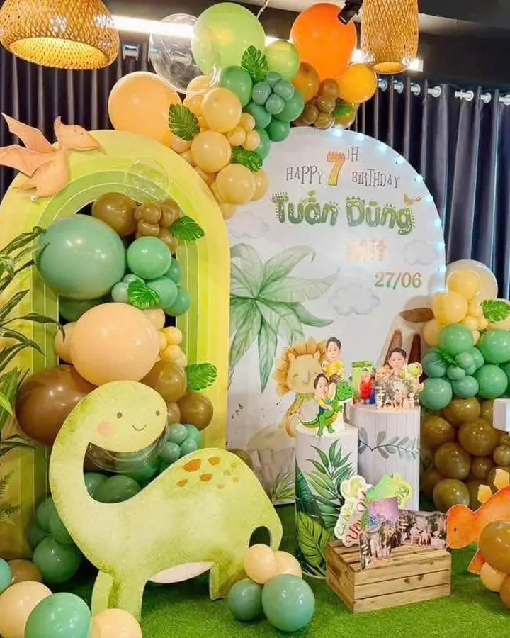 Trang trí sinh nhật chủ đề khủng long với cổng vòm và bong bóng xanh lá, cam